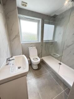 A modern, clean bathroom featuring a large wind...