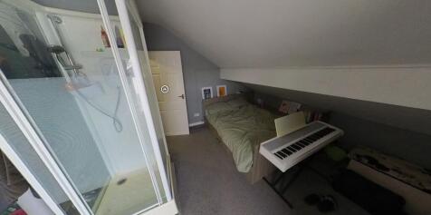 A cozy bedroom featuring a single bed, a desk a...