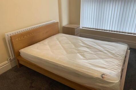 A spacious double bedroom with a large window p...