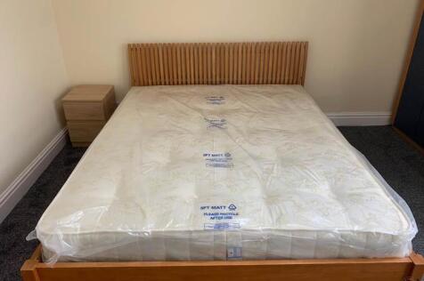 A spacious master bedroom featuring a comfortab...