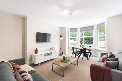 Bright and spacious living room featuring large...