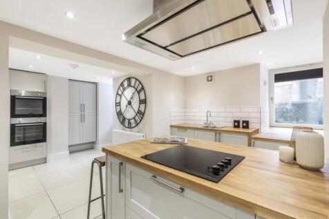 Bright and modern kitchen featuring a large cen...
