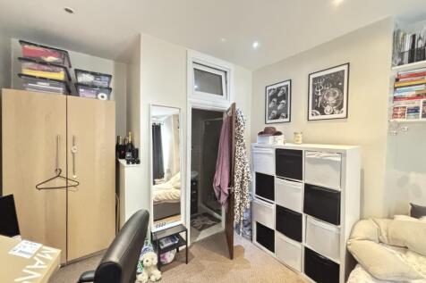 A cozy bedroom featuring a wardrobe, a mirror, ...