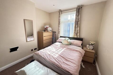 A cozy and well-lit bedroom featuring a comfort...