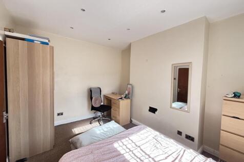 A bright and tidy bedroom featuring a double be...