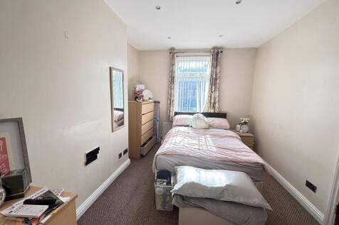 A cozy bedroom featuring a single bed with a pi...