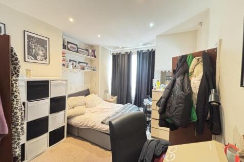 Cozy student bedroom featuring a double bed, fu...