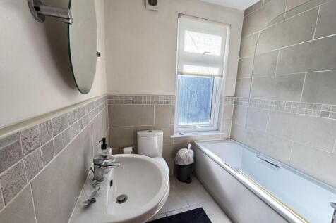 A well-maintained bathroom with a bathtub, sink...