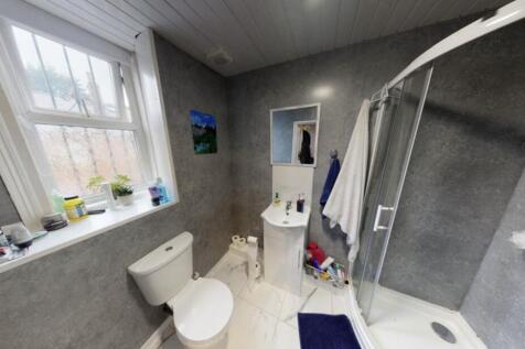 A clean, bright bathroom with a large bathtub a...