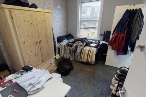 A cozy bedroom featuring a bed, wardrobe, and s...