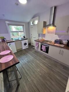 Bright and modern kitchen featuring large windo...