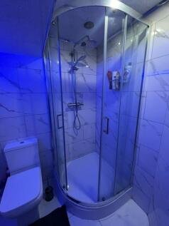 A modern, clean bathroom featuring a glass-encl...