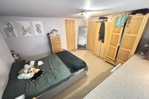 A cozy student bedroom featuring a double bed, ...