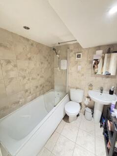 A modern bathroom featuring a bathtub with a sh...