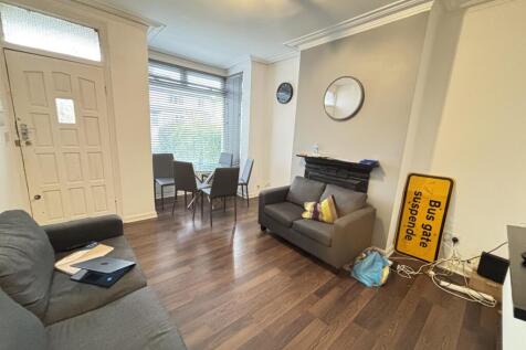 A well-lit and inviting living room with comfor...