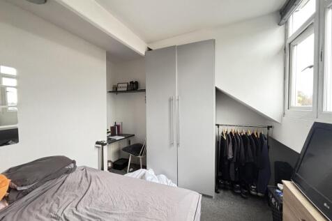 A bright, tidy bedroom featuring a comfortable ...