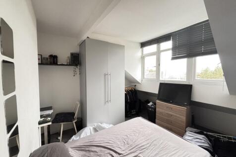 A bright and tidy bedroom featuring a comfortab...