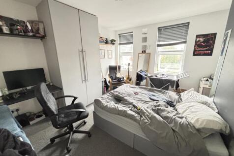 A bright and inviting bedroom featuring a comfo...