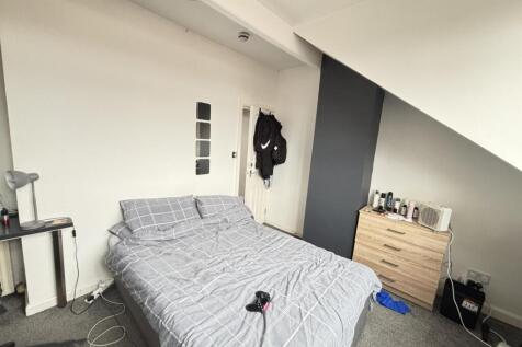 A tidy and well-lit bedroom featuring a double ...