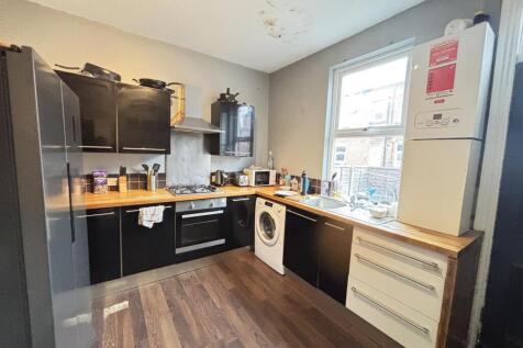 A modern kitchen with ample natural light, feat...
