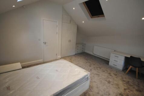 A cozy single bedroom with a neatly made bed, b...