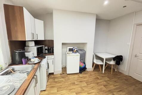 A contemporary kitchen area featuring white cab...