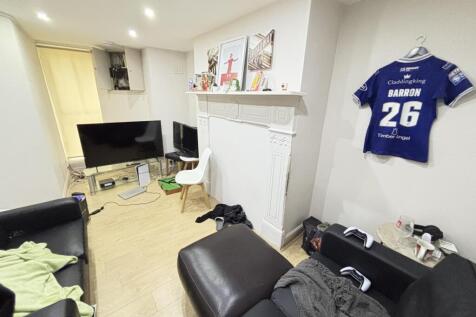 A cozy living room with a sofa, TV, and some pe...