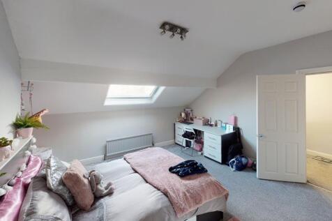 A cozy bedroom with a large bed, soft pillows, ...