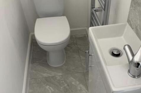 A clean and modern bathroom featuring a toilet ...