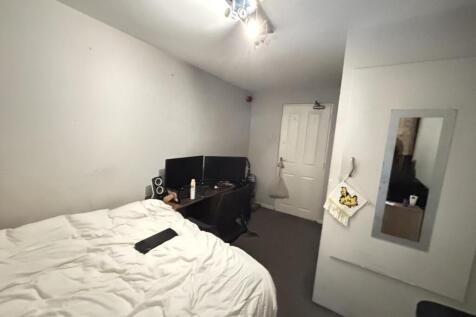 A spacious master bedroom featuring a comfortab...