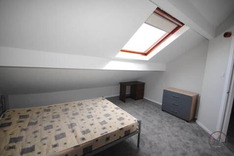 A spacious, well-lit bedroom with a large skyli...