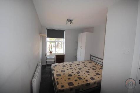 A modest bedroom featuring a double bed with a ...