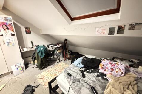 A spacious bedroom with a large bed, featuring ...