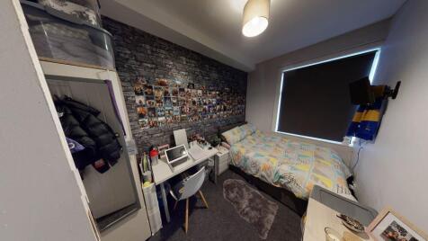 A cozy single bedroom featuring a neatly made b...