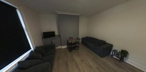 A spacious and well-lit living room featuring m...