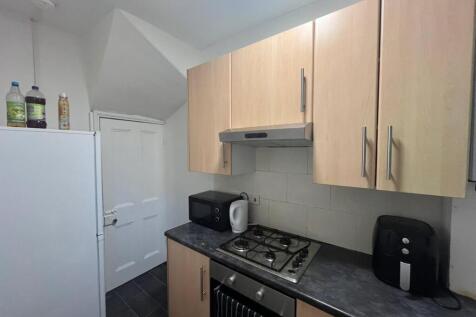 A modern, clean kitchen with wooden cabinets, a...