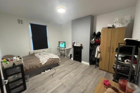 A well-lit bedroom featuring a double bed, a wa...