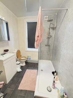 A well-maintained bathroom featuring a shower, ...