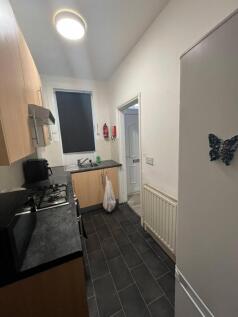 A modern and tidy kitchen area with wooden cabi...
