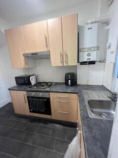 A modern kitchen area with wooden cabinets, a s...