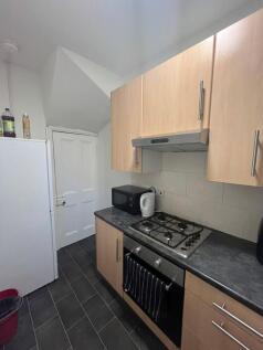 Modern compact kitchen area with light wooden c...