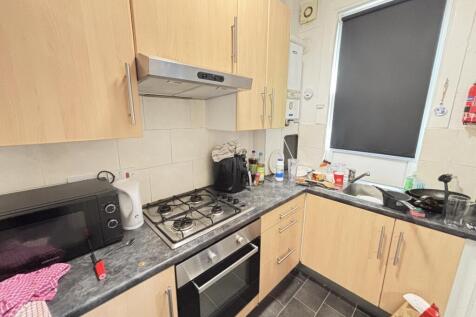 A compact kitchen area with modern fitted units...