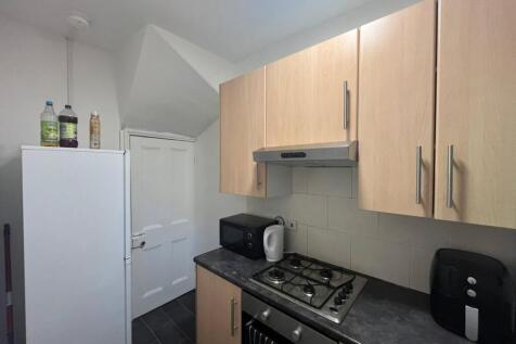 A modern kitchen with wooden cabinets, a white ...