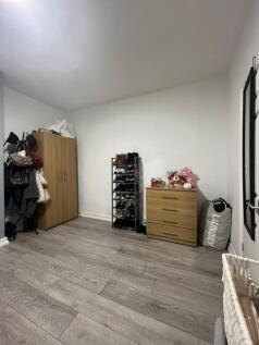 A cozy bedroom featuring a wardrobe, a small ch...