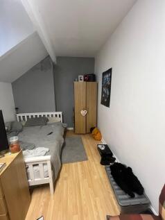 A cozy single bedroom featuring a bed, a wardro...