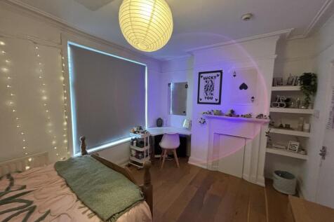 Cozy and well-lit bedroom featuring soft lighti...