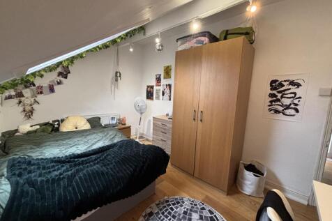 A cozy bedroom featuring a double bed, a wardro...