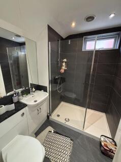 A modern bathroom featuring a walk-in shower wi...