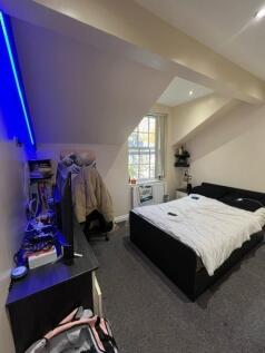 A well-lit double bedroom featuring a comfortab...