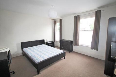 A well-lit double bedroom featuring a comfortab...